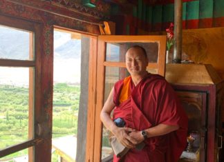 Achtsamkeitsübungen mit buddhistischem Mönch – Meditieren im Hotel tibetischer-mönch-steht-vor-geöffnetem-fenster