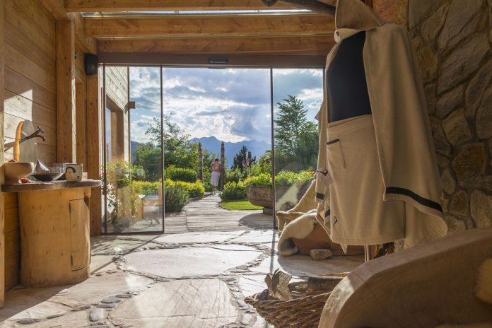 spa-bereich-mit-steinfließen-mit-offener-tür-in-den-garten