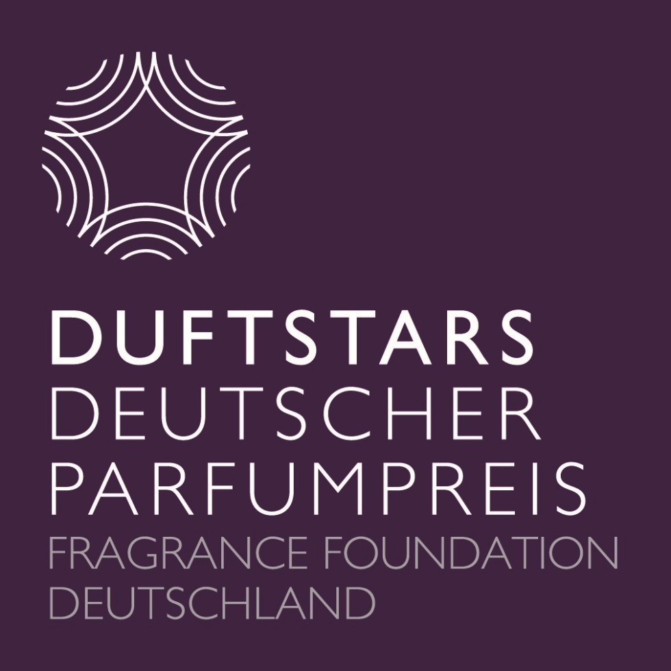 frau-mit-kurzen-blonden-haaren-riecht-an-parfum-flacon