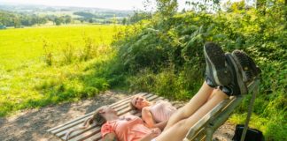 zwei-frauen-liegen-verkehrtrum-auf-einer-bank