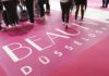 Man erkennt die Beine von Menschen, die über einen rosa farbenen Teppich mit der Aufschrift Beauty Düsseldorf laufen.