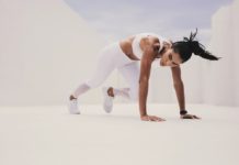 Athletic woman in push up position bringing her leg forward. Woman doing fitness training with her hands on the floor.