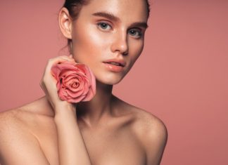 Junge Frau mit Rosenblüte in der Hand