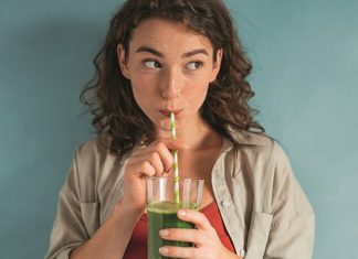Junge Frau beim Trinken eines grünen Smoothies