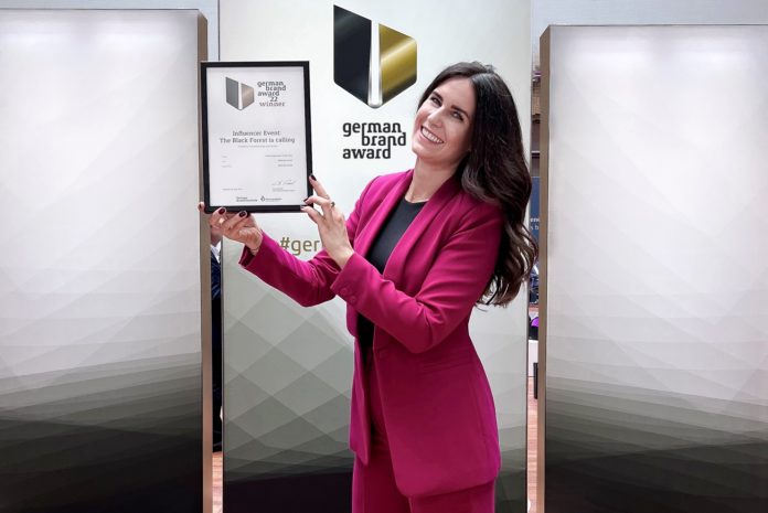 Katrin Stockinger, Head of Communication hält eine Urkunde in den Händen