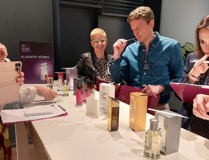 Männer und Frauen testen verschiedene Parfums.