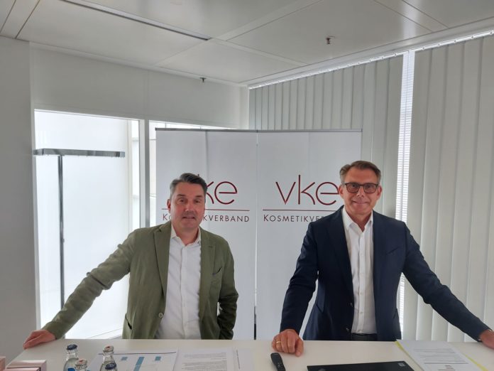 Zwei Männer in Anzügen: Markus Grefer und Martin Ruppmann vom VKE stehen vor einem Banner des Verbands.