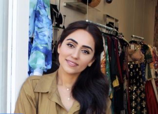 Von Influencern empfohlen Junge Frau mit Kleidung auf Stange im Hintergrund