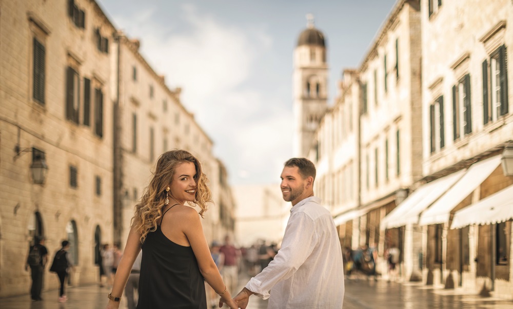 Junges Paar geht händchenhaltend durch die Altstadt von Dubrovnik