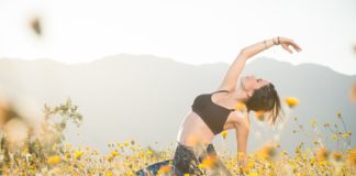 A young Hispanic women doing yoga in the desert during a spring bloom of wild flowers.