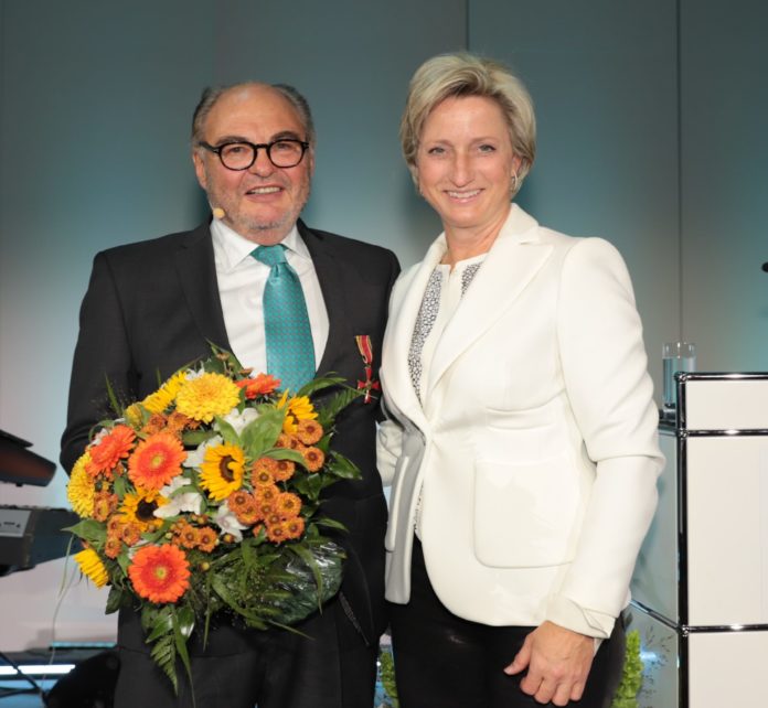 Michael Lindner und Frau Dr. Hoffmeitster-Kraut. Herr Lindner hält einen bunten Blumenstrauß in der Hand.