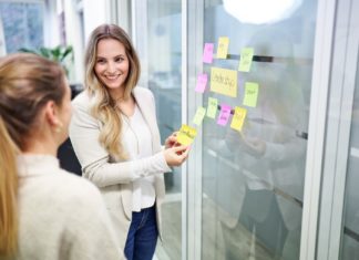 Mäurer & Wirtz erneut ausgezeichnet Zwei Frauen stehen vor einer mit Post-Its beklebten Glasfront