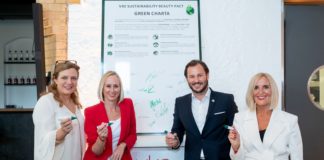 Drei Frauen und ein Mann stehen vor einem übergroßen Charta-Ausdruck. Sie halten Stifte in der Hand.