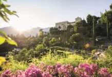 Blühende Gärten im Sonnenschein mit Schloss Trauttmansdorff im Hintergrund