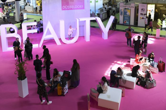 Menschen auf rosa Teppich vor großeme Beauty-Schriftzug
