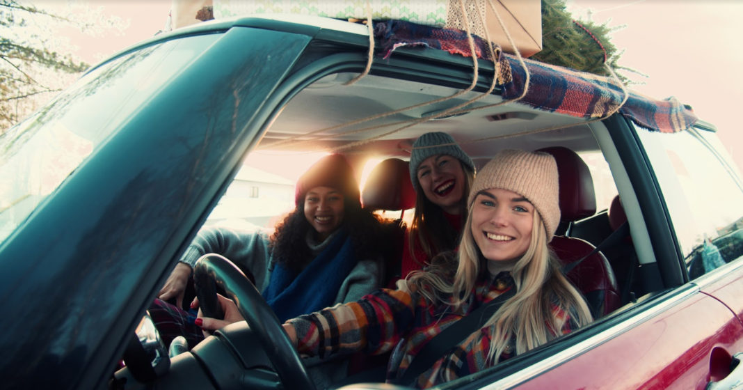 Drei junge Frauen in Winterkleidung sitzen in enem Auto.
