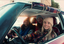 Umfrage enthüllt Reisetrends für Weihnachten & Neujahr Drei junge Frauen in Winterkleidung sitzen in enem Auto.