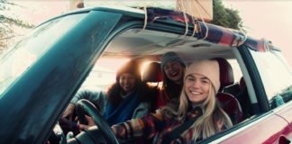 Drei junge Frauen in Winterkleidung sitzen in enem Auto.