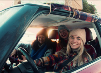 Drei junge Frauen in Winterkleidung sitzen in enem Auto.