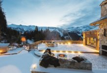 Blick von einer verschneiten Hotelterrasse auf die Berge.