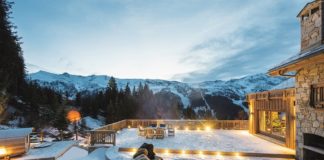 Blick von einer verschneiten Hotelterrasse auf die Berge.