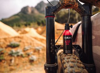 Eine Flasche des Männderduftes Tabac steht auf Mountainbikereifen.