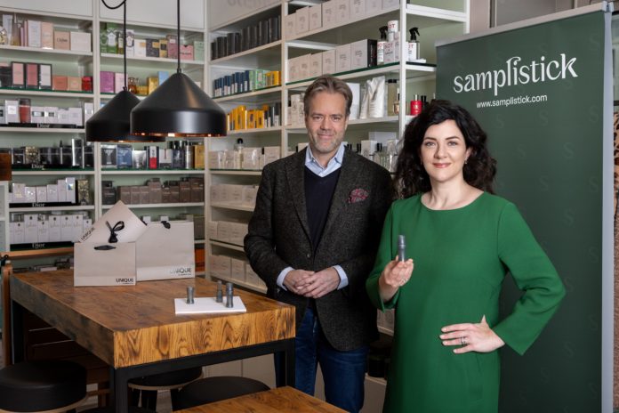 Ein Mann und eine Frau im grünen Kleid stehen im Verkaufsraum mit Regalen.