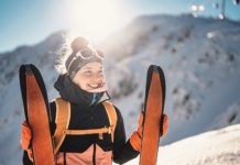 Mountaineer backcountry ski walking ski alpinist in the mountains. Ski touring in alpine landscape with snowy trees. Adventure winter sport.