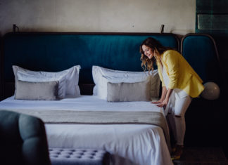 Heute schon gelüftet? Wie Düfte zu Hause unser Wohlbefinden beeinflussen Junge Frau beim Bettenmachen.