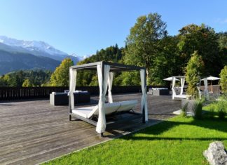 Was hilft wirklich gegen Stress und wie stärke ich mein Immunsystem am besten? Überdachtes Bett mit Vorhängen zum Entspannen inmitten einer Bergkulisse