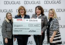 DOUGLAS spendet 100.000 Euro an DKMS LIFE Vier Frauen halten einen großen Scheck in die Kamera.