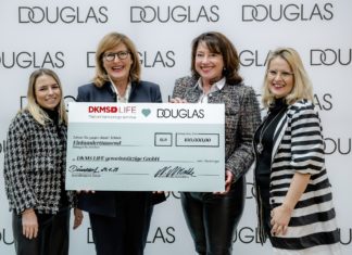 DOUGLAS spendet 100.000 Euro an DKMS LIFE Vier Frauen halten einen großen Scheck in die Kamera.