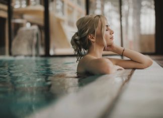 Sensual young woman relaxing in spa swimming pool