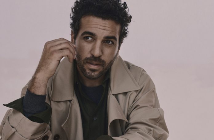 Der Schauspieler Elyas M´Barek in hellem Trenchcoat.