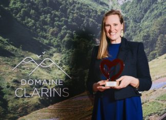 Eine Frau mit langen Haaren hält den Clarins Prix in den Händen.