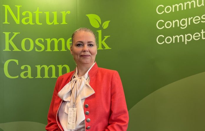 Veranstalterin Katrin Hiersche vor dem Banner des NaturKosmetikCamps