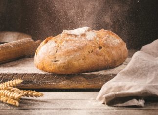 Brotlaib auf mit Mehl bestäubtem Holztisch