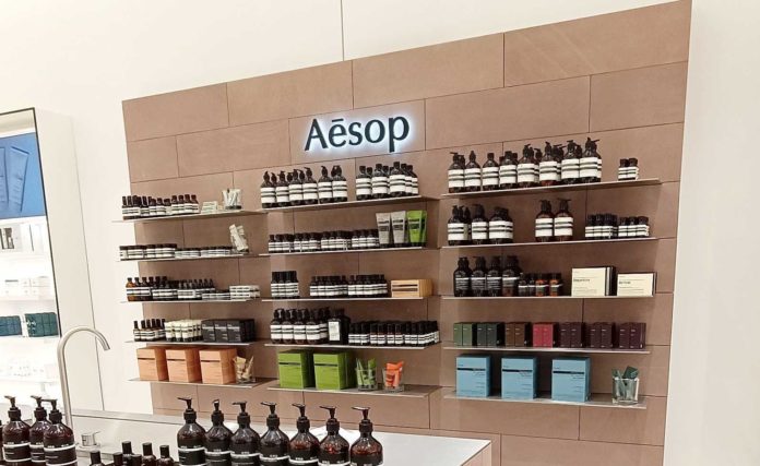 Regal einer Parfümerie, bestückt mit Produkten der Marke Aesop.