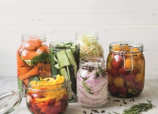 Pickled vegetables. Salting various vegetables in glass jars for long-term storage. Preserves vegetables in glass jars. Variety fermented green vegetables on table.