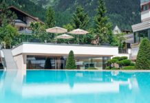 Infinity-Pool mit Gebäude und Bäumen im Hintergrund