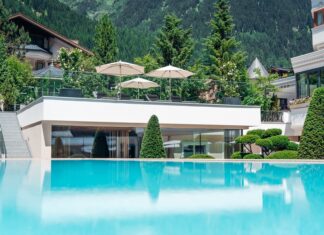 Infinity-Pool mit Gebäude und Bäumen im Hintergrund