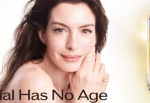 Shiseido: Anne Hathaway ist neuer Global Ambassador für Vital Perfection Frau blickt lächelnd in die Kamera, neben ihr stehen zwei Kosmetikprodukte von Shiseido