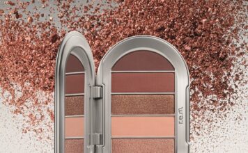 Lidschatten in verschiedenen Rosé-Tönen in silberner Dose; im Hintergrund metallicfarbene Partikel
