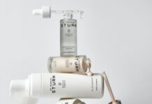 PUIG erwirbt Mehrheitsbeteiligung an Dr. Barbara Sturm Verschiedene Produkte wie Tigel, Pipette, Fläschen, sind zu einem Turm gestapelt.