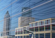 Die Mega-Messe der Konsumgüterbranche baut weltweite Führungsposition aus Spiegelung der Skyline mehrerer Gebäude in einer gläsernen Häuserfront