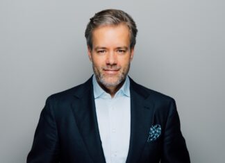 Start frei für rocket.beauty Mann mit dunklem Blazer, hellblauem Hemd und gepunktetem Einstecktuch blickt frontal in die Kamera.