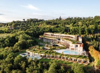 Garten der Sinne – A-ROSA eröffnet erstes Hotel in Italien Blick auf ein Hotelgebäude mit Pool, eingebettet in einen grünen Hügel.