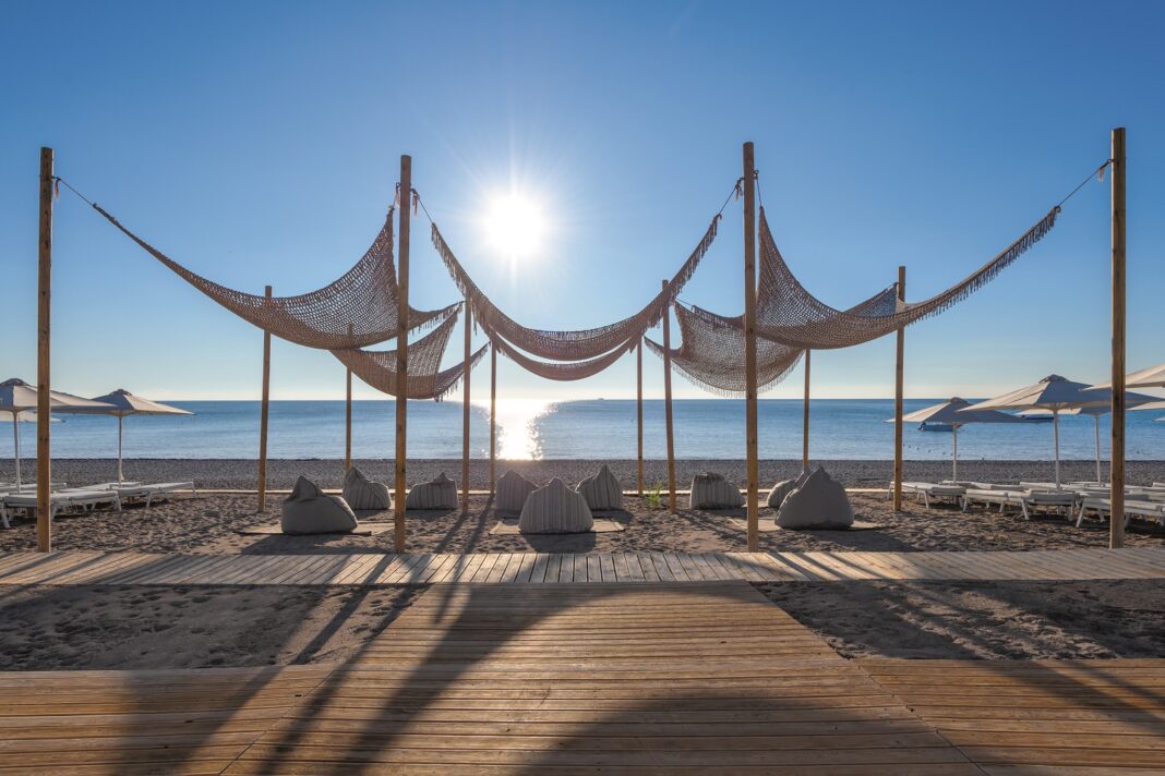 Mit Netzen überspannte Holzterrasse auf dem Strand am Meer.