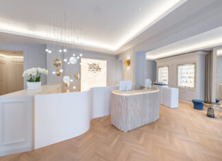 Münchner „Ambassade“ von Biologique Recherche hell gestalteter Empfangsbereich mit Tresen, indirekt beleuchtet