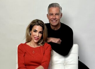 Michael Schummert ist neuer CEO von Doctor Mi Eine Frau in rotem Pullover sitzt in einem weißen Sessel. Ein Mann in schwarzem Oberteil lehnt sich über die Rückenlehne.